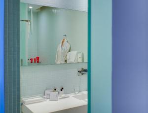 La salle de bains est pourvue d'un lavabo et d'un miroir. dans l'établissement Hôtel de Bourgtheroulde, Autograph Collection, à Rouen