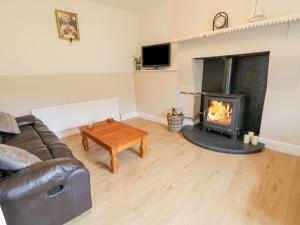 a living room with a couch and a fireplace at Maghera Caves Cottage in Ardara