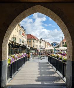 an archway over a boardwalk in a city with flowers at Villa Warempel in Valkenburg