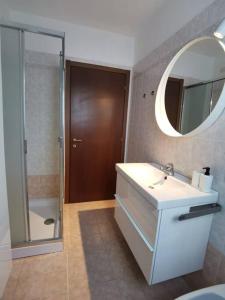 ein Bad mit einem Waschbecken, einem Spiegel und einer Dusche in der Unterkunft Flo House, Università Bicocca in Mailand