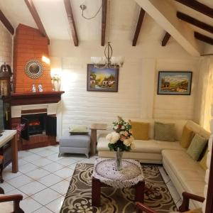 a living room with a couch and a fireplace at HERMOSA Y COMODA CASA FAMILIAR EN Baños in Baños