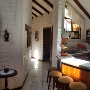 una cucina con bancone e sgabelli in una stanza di HERMOSA Y COMODA CASA FAMILIAR EN Baños a Baños
