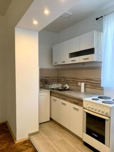 een keuken met witte kasten en een fornuis met oven bij Central City Apartment in Skopje