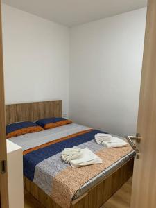 een slaapkamer met een bed met twee handdoeken erop bij Central City Apartment in Skopje