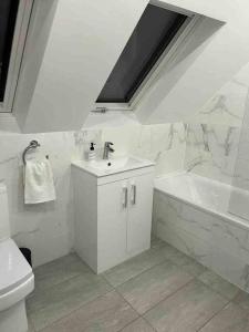 uma casa de banho com um lavatório, uma banheira e um WC. em stunning cinematic 2 bed em Hendon