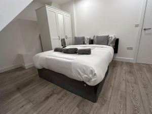 uma cama grande num quarto com piso em madeira em stunning cinematic 2 bed em Hendon