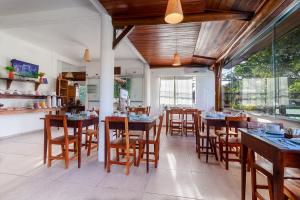 une salle à manger avec des tables et des chaises en bois dans l'établissement Pousada Pé na Estrada, à Arraial d'Ajuda