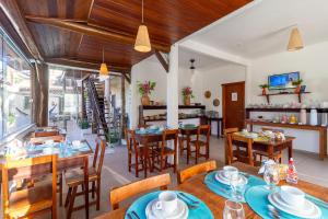 a dining room with wooden tables and chairs at Pousada Pé na Estrada in Arraial d'Ajuda