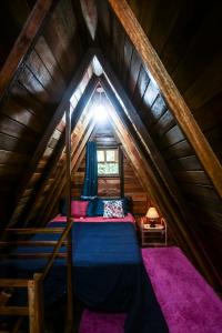 a bedroom with a bed in a attic at Chalé cercado de muito verde a 9km de Sto Antonio do Pinhal - Área rural in Santo Antônio do Pinhal