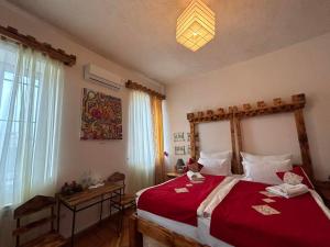 a bedroom with a large bed with a red blanket at Machanents Art Hotel in Vagharshapat