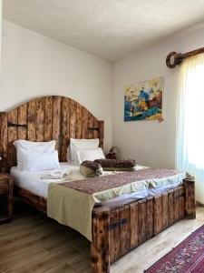 um quarto com uma cama grande e uma cabeceira em madeira em Machanents Art Hotel em Vagharshapat