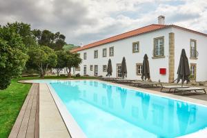 una villa con piscina di fronte a un edificio di Convento do Seixo Boutique Hotel & Spa a Fundão