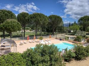 a swimming pool with lounge chairs and a fence at Logis Hôtel Le Manoir & Lounge in Apt