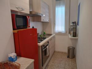 una piccola cucina con frigorifero rosso e forno a microonde di il 64B - 10 minuti a piedi dal Policlinico San Matteo - a Pavia