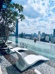 a swimming pool with two paper shoes on the edge of a building at Axon Serviced Suites Kuala Lumpur in Kuala Lumpur
