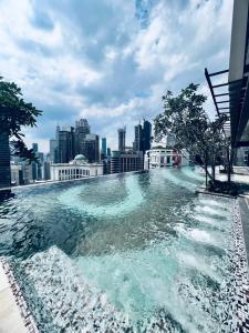 een zwembad bovenop een gebouw met een skyline van de stad bij Axon Serviced Suites Kuala Lumpur in Kuala Lumpur