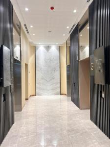a hallway with a marble wall in a building at Axon Serviced Suites Kuala Lumpur in Kuala Lumpur