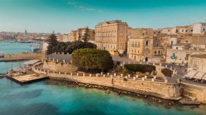 an aerial view of a city with a body of water at Panorama Alfeo in Siracusa