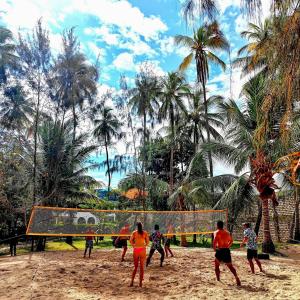 eine Gruppe von Menschen, die eine Partie Volleyball am Strand spielen in der Unterkunft Soul Breeze Beach Resort in Diani Beach