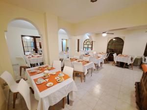 a restaurant with white tables and white chairs at Hotel Provincia in Trelew