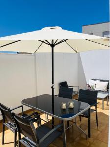 einen schwarzen Tisch und Stühle mit einem Sonnenschirm in der Unterkunft Apartamento JALAMA 1D in Moraleja