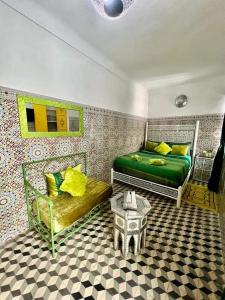 a bedroom with two beds and a table in it at Riad 1001 couleurs in Marrakesh