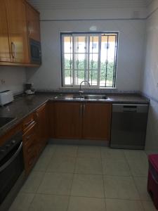 a kitchen with wooden cabinets and a sink and a window at Villa V2 V in Olhos de Água