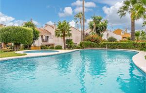una piscina in un cortile con palme e case di Stunning Home In Estepona With Kitchen 