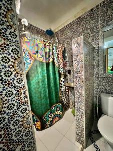 baño con ducha con cortina verde en Riad 1001 couleurs en Marrakech