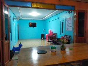 a room with a table and a blue wall at เดอะเบสท์ พูลวิลล่า ขนอม in Ban Tha Chan