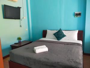 a blue room with a bed with a towel on it at เดอะเบสท์ พูลวิลล่า ขนอม in Ban Tha Chan