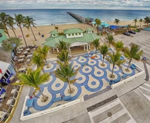 an aerial view of a resort with palm trees and the beach at Ocean Flats 1 - Lauderdale-by-the-Sea in Fort Lauderdale
