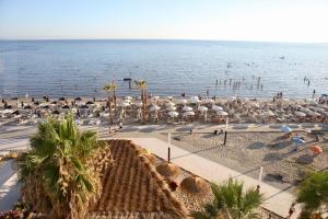 uma praia com muitos guarda-sóis e a água em Volmar Hotel em Durrës