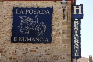 un cartel en la pared de un edificio en Hotel la posada de Numancia en Garray