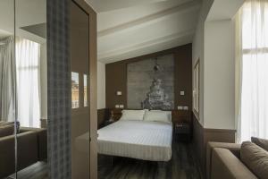 ローマにあるホテル レグノのベッドルーム(ベッド1台、ソファ付)