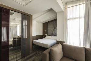 ein Schlafzimmer mit einem Bett, einem Sofa und einem Fenster in der Unterkunft Hotel Regno in Rom