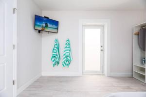 a living room with a flat screen tv on a wall at Ocean Flats 4 - Lauderdale-by-the-Sea in Fort Lauderdale