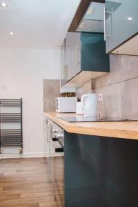 a kitchen with a counter top with two microwaves at Nicely made relaxing 4 Bedroom near LFC Stadium in Liverpool