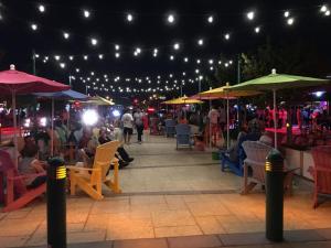 a group of people sitting under umbrellas at a market at night at Ocean Flats 4 - Lauderdale-by-the-Sea in Fort Lauderdale