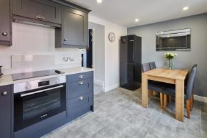 a kitchen with blue cabinets and a wooden table at Host & Stay - Castle View Cottage in Barnard Castle