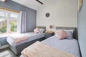 two beds in a room with a window at Host & Stay - Castle View Cottage in Barnard Castle