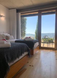 een slaapkamer met twee bedden en een groot raam bij Quinta de Santa Marinha in Castedo