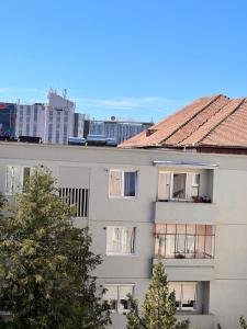 a white building with trees in front of it at Apartament central Milea in Sibiu