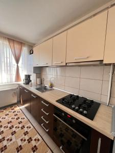 a kitchen with wooden cabinets and a stove top oven at Apartament central Milea in Sibiu