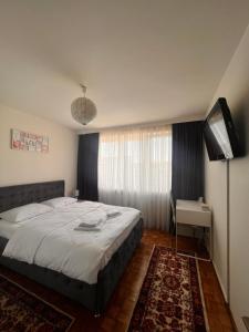 a bedroom with a bed and a flat screen tv at Apartament central Milea in Sibiu