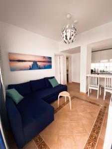 un soggiorno con divano blu e una cucina di Casa Fuerteventura a Costa Calma