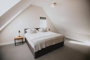 een witte slaapkamer met een bed op zolder bij The Bothy at Aikenshill in Aberdeen