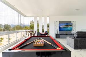 una sala de estar con una mesa de billar con murciélagos. en Casa Na Praia em Angra dos Reis en Angra dos Reis