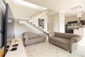 una sala de estar con 2 sofás y una escalera en Casa Na Praia em Angra dos Reis, en Angra dos Reis