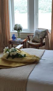 a bed with a yellow blanket and flowers on it at Lochwood Guest House in Lochgoilhead